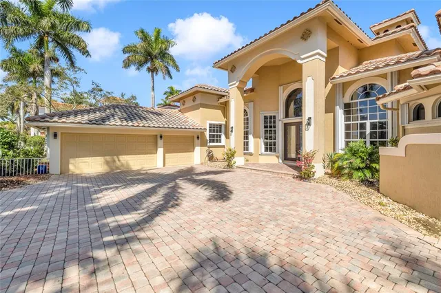 a view of a white house with a yard and plants