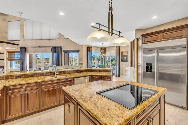 a kitchen with stainless steel appliances granite countertop a sink and a refrigerator