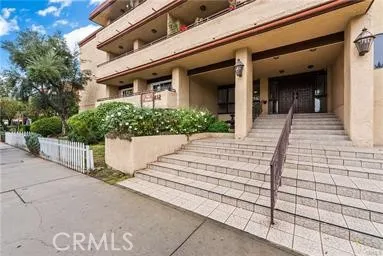 a view of a house with potted plants and a pathway