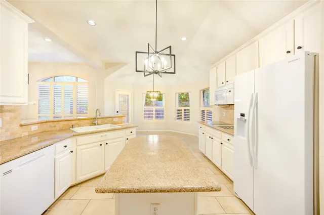 a large white kitchen with a large window