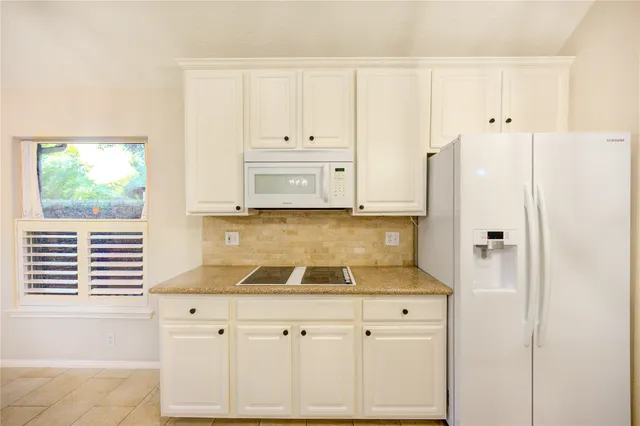 a view of a kitchen with kitchen island a counter top space appliances and cabinets