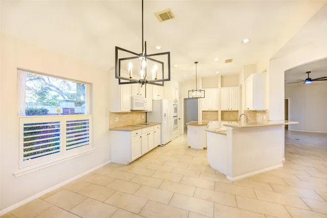 a large white kitchen with a large window