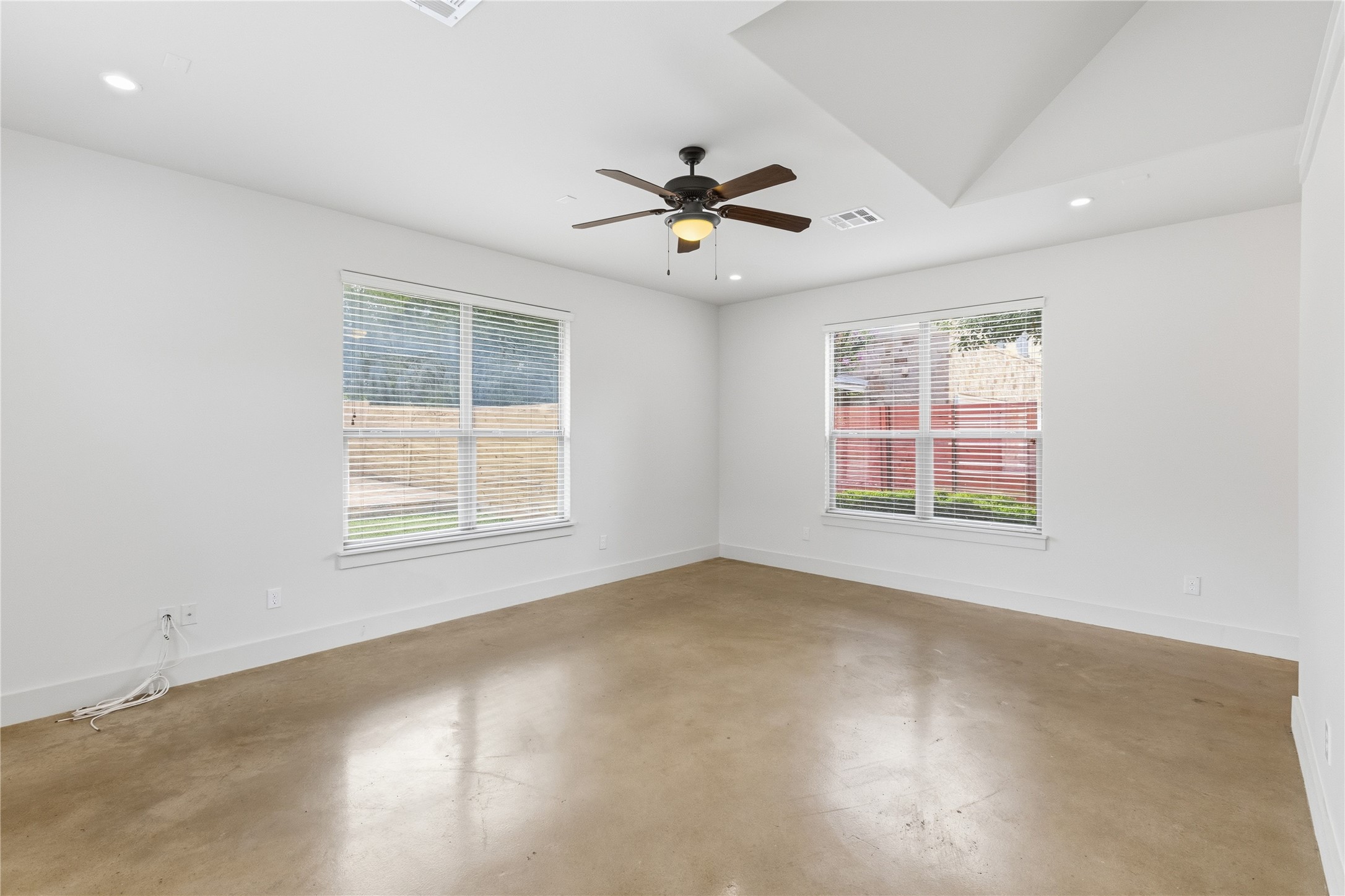 4124 Valley View Road, Unit 4B Austin, TX 78704 - Photo 10 of 32 A quiet bedroom featuring sleek concrete flooring and a tray ceiling with a modern fan.