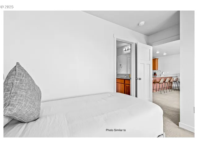 a bedroom with a bed and a view of kitchen