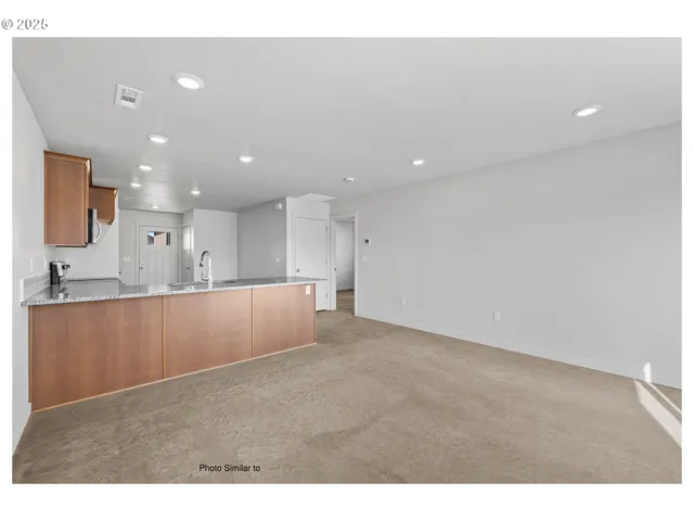 a view of kitchen with kitchen island and stainless steel appliances