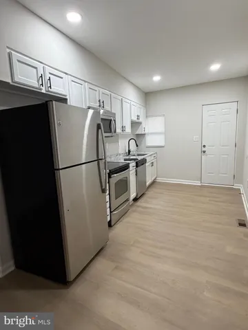 a kitchen with stainless steel appliances granite countertop a refrigerator and a stove