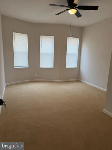 an empty room with a window and a ceiling fan