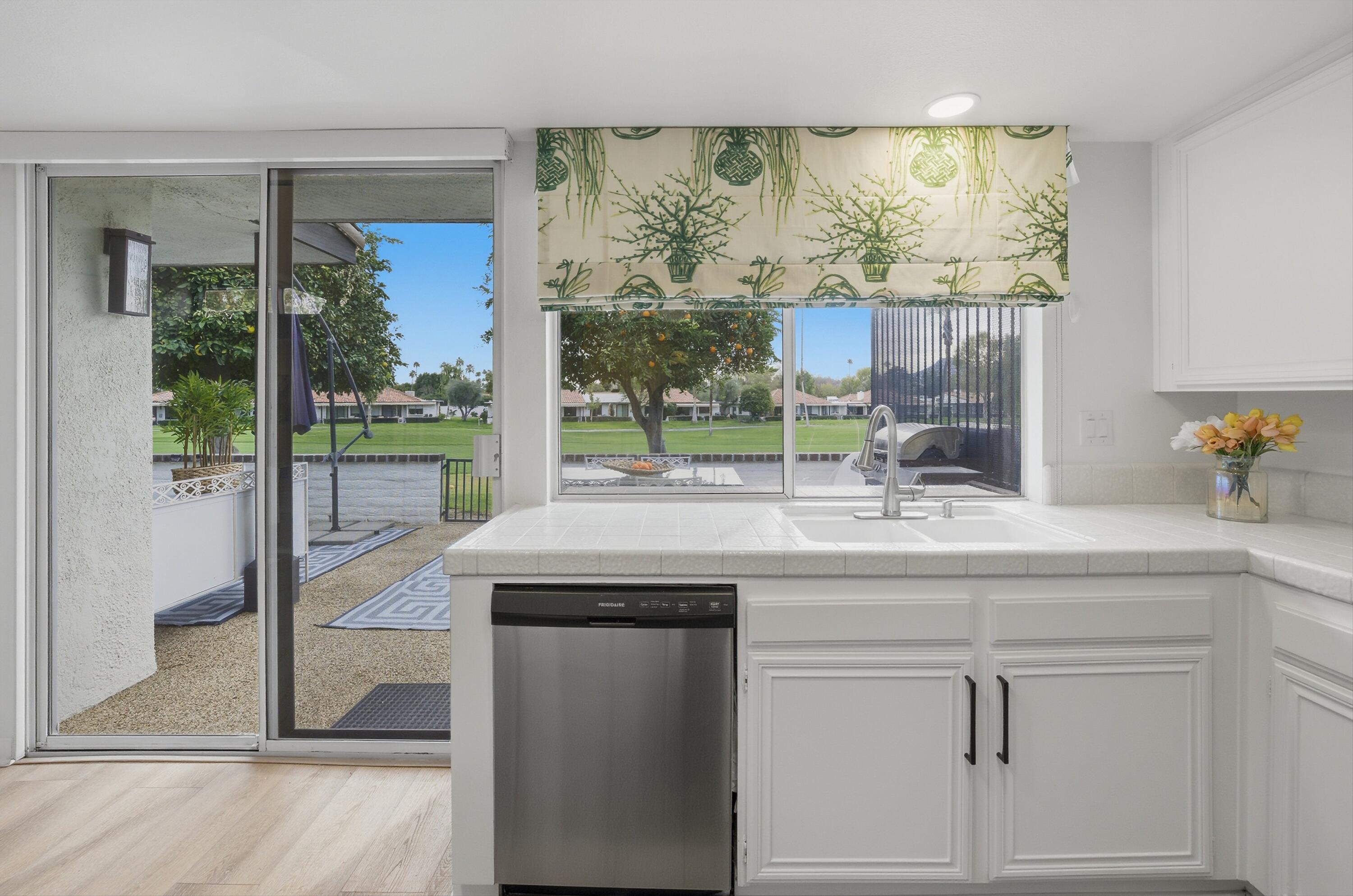 23 Leon Way Rancho Mirage, CA 92270 - Photo 13 of 32 a kitchen with a sink and a large mirror next to a window