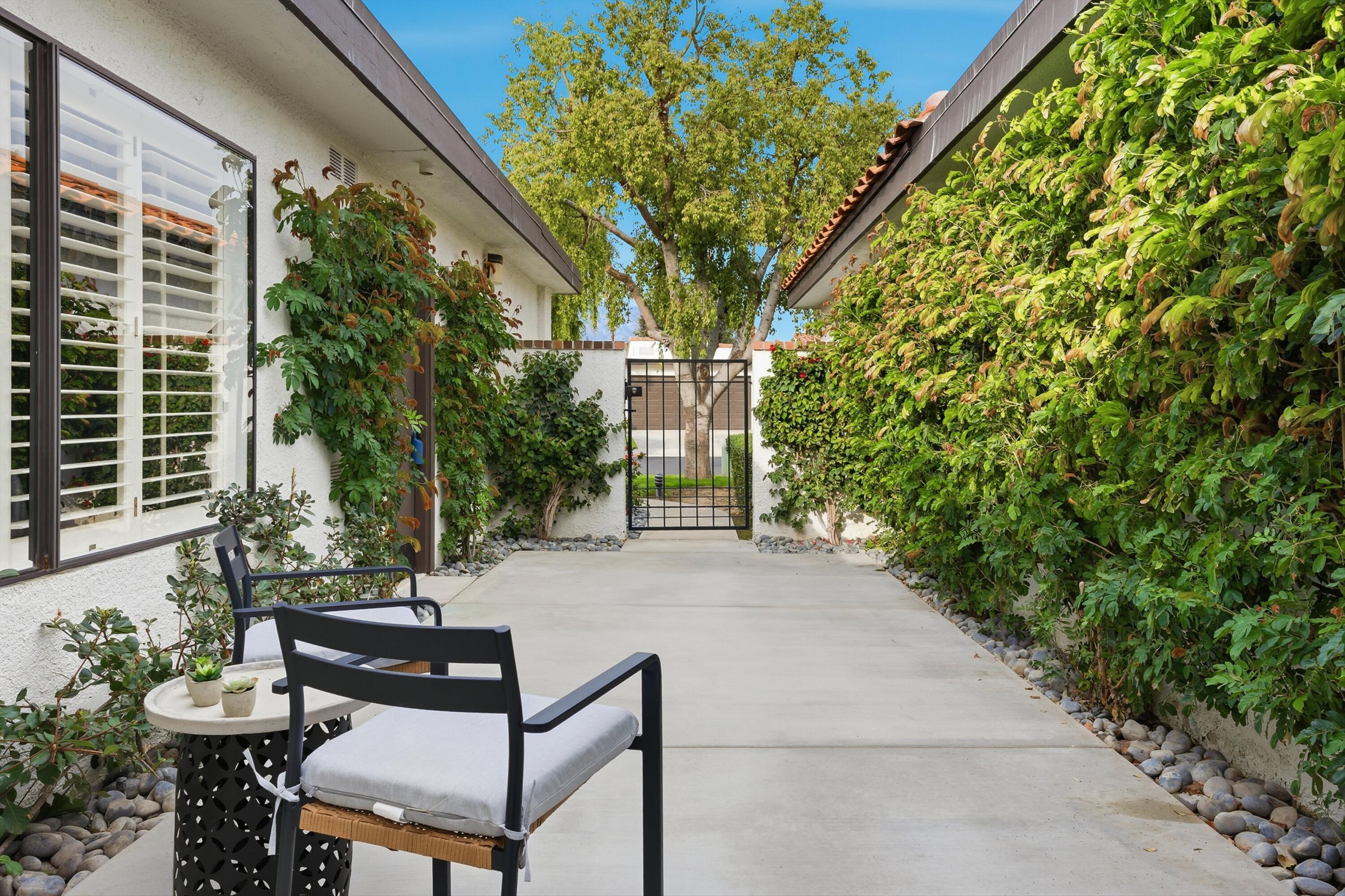 23 Leon Way Rancho Mirage, CA 92270 - Photo 25 of 32 a view of backyard with a table and chairs and potted plants