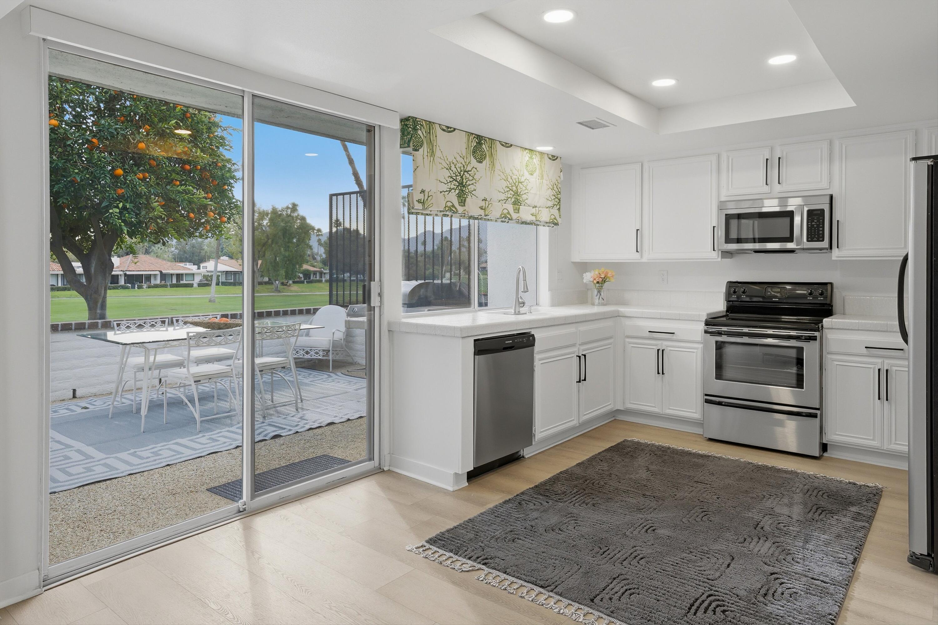 23 Leon Way Rancho Mirage, CA 92270 - Photo 10 of 32 a kitchen with stainless steel appliances a stove sink and glass door