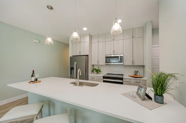 a kitchen with a sink a counter and chairs