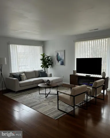 a living room with furniture a window and a flat screen tv