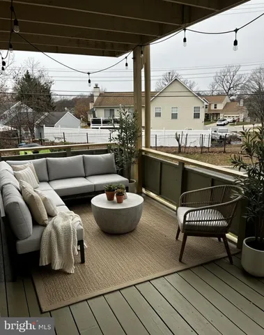 a view of roof deck with couches and potted plants