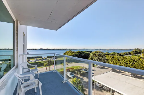 a view of a balcony with chairs and wooden floor
