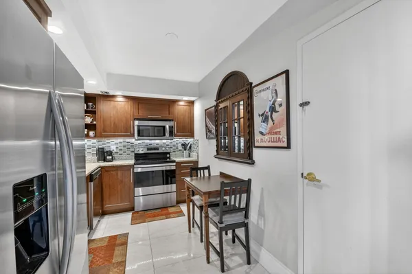 a kitchen with stainless steel appliances granite countertop a refrigerator and a stove top oven