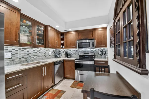 a kitchen with stainless steel appliances granite countertop a sink stove and microwave