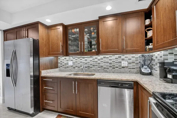 a kitchen with stainless steel appliances granite countertop a refrigerator and a sink