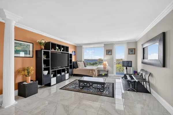a living room with furniture a flat screen tv and a floor to ceiling window