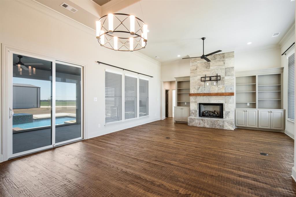 470 Forreston Road Waxahachie, TX 75165 - Photo 19 of 38 Unfurnished living room featuring visible vents, ceiling fan with notable chandelier, recessed lighting, a fireplace, and crown molding