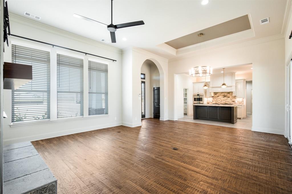 470 Forreston Road Waxahachie, TX 75165 - Photo 22 of 38 Unfurnished living room featuring arched walkways, visible vents, ceiling fan with notable chandelier, and ornamental molding