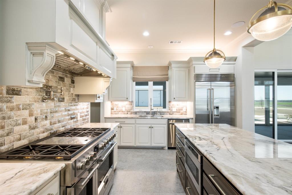 470 Forreston Road Waxahachie, TX 75165 - Photo 24 of 38 Kitchen with visible vents, a sink, white cabinets, built in appliances, and hanging light fixtures