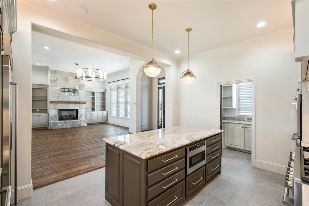 470 Forreston Road Waxahachie, TX 75165 - Photo 26 of 38 Kitchen with a kitchen island, crown molding, and light stone countertops