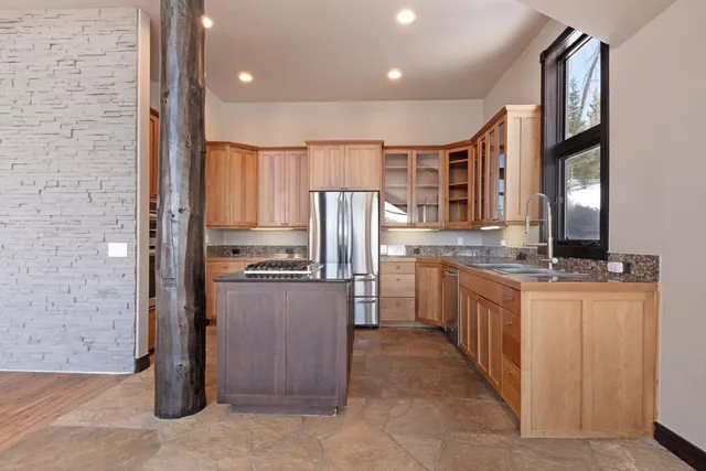 a kitchen with stainless steel appliances granite countertop a refrigerator and a sink