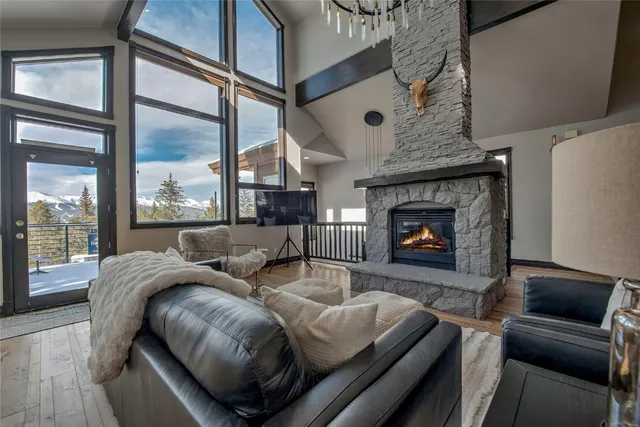 a living room with furniture a large window and wooden floor