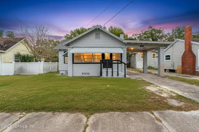 a front view of a house with a garden and yard