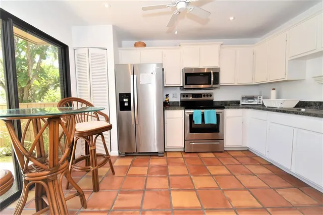 a kitchen with stainless steel appliances kitchen island granite countertop a refrigerator and a stove top oven