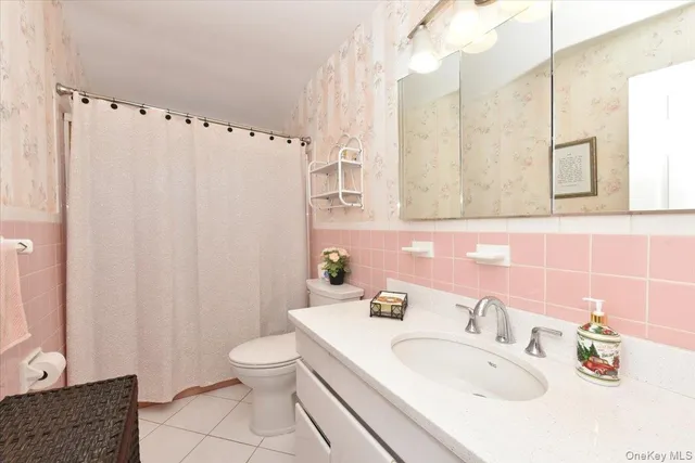 a bathroom with a sink a toilet and a mirror