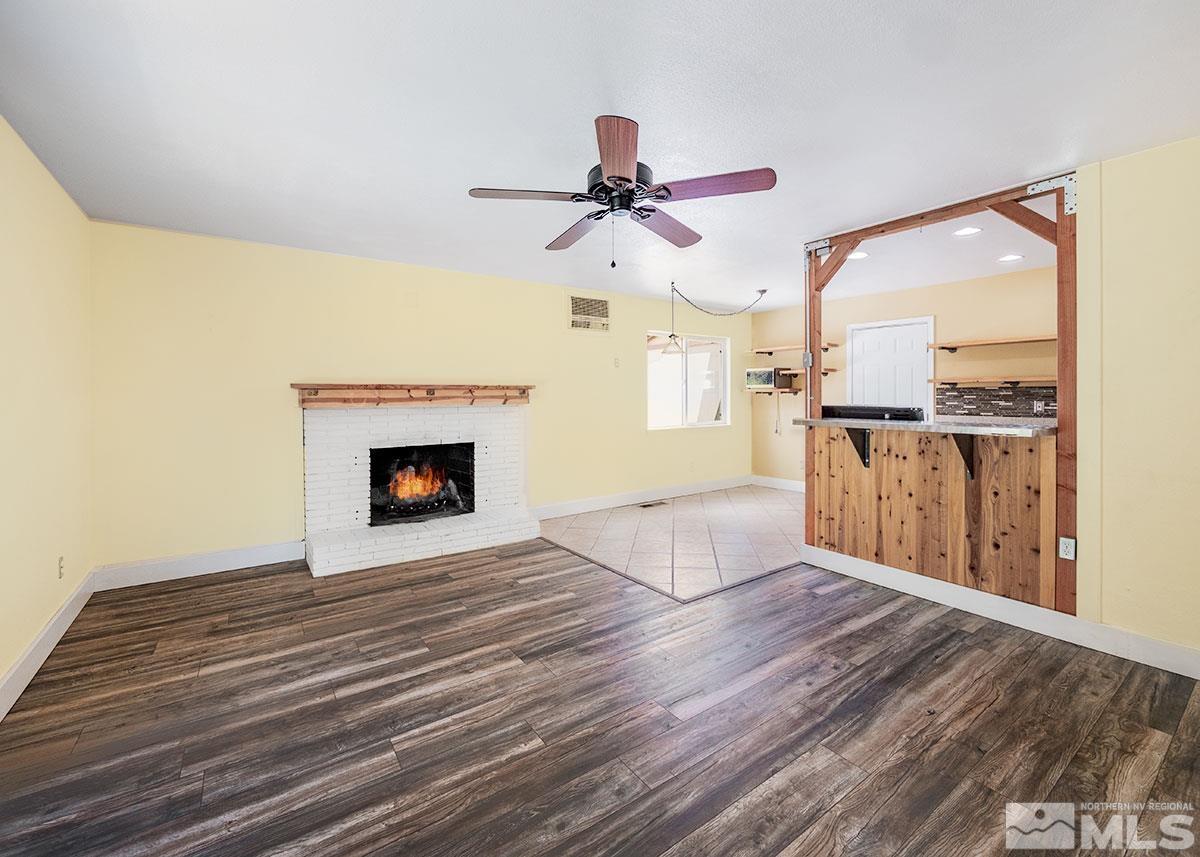 7501 Essex Way Reno, NV 89506 - Photo 3 of 15 a view of a livingroom with a fireplace and wooden floor