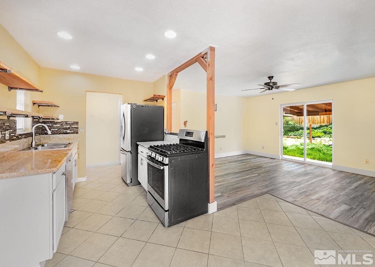 7501 Essex Way Reno, NV 89506 - Photo 5 of 15 a kitchen with stainless steel appliances granite countertop a stove a sink and a refrigerator