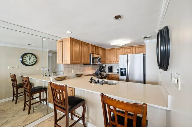 a kitchen with stainless steel appliances a table chairs and a refrigerator