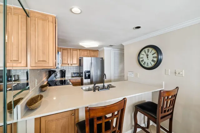 a kitchen with a table chairs and a clock on the wall