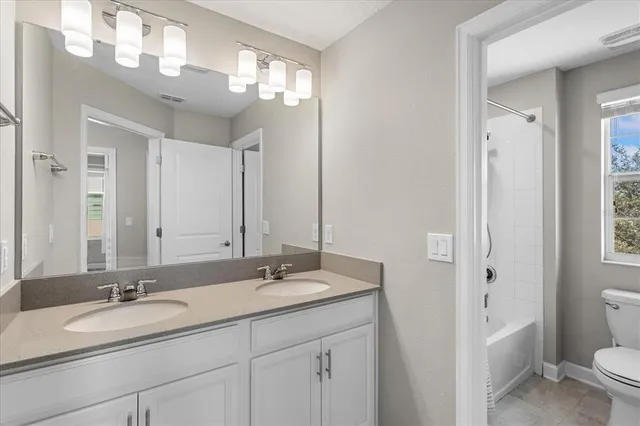 a bathroom with a double vanity sink and a mirror