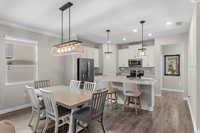 a view of a dining room and a kitchen with a table chairs