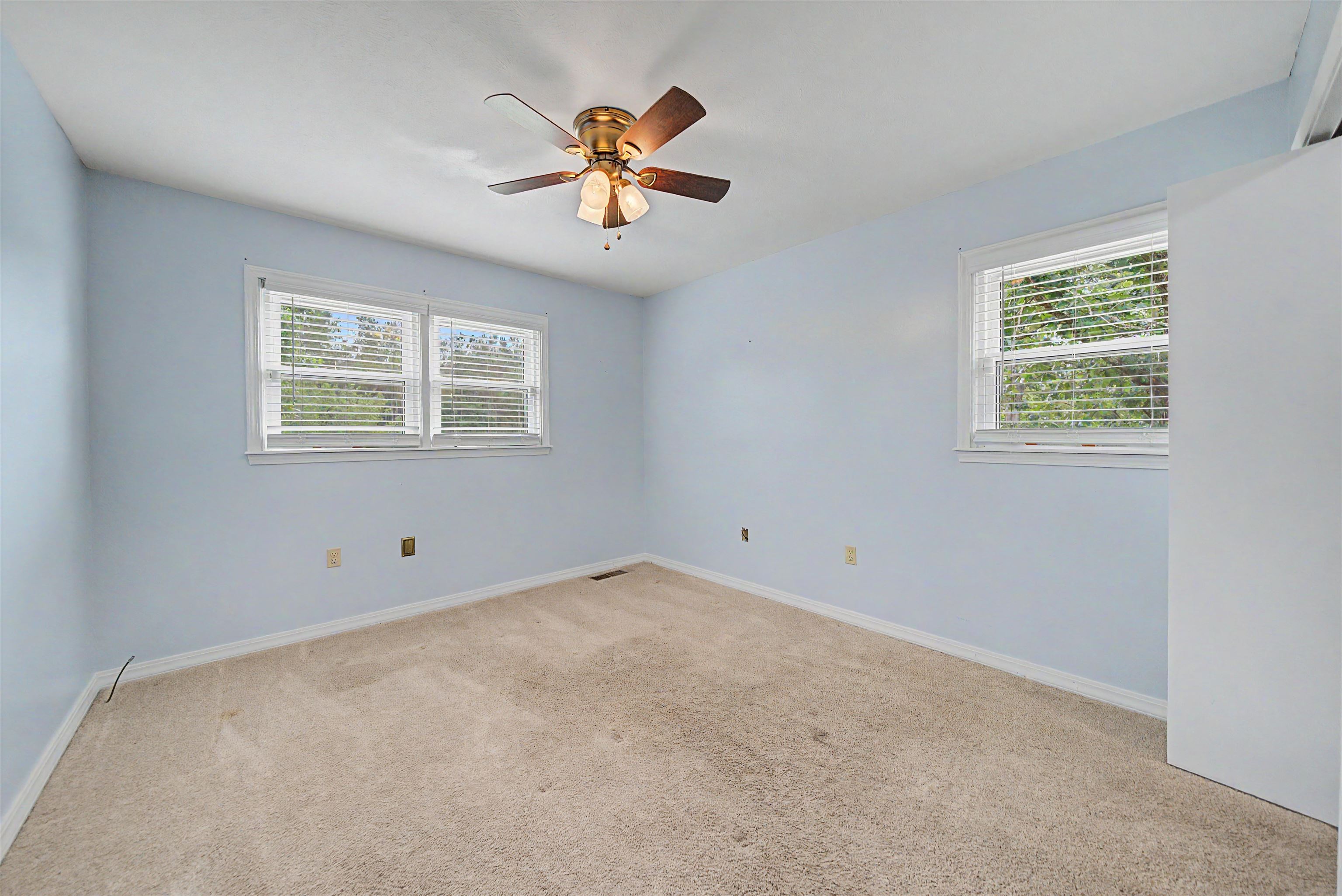 436 Skyline Road Selmer, TN 38375 - Photo 20 of 40 Bright room featuring two windows with horizontal blinds, a ceiling fan with light fixture, carpet flooring, and light blue walls