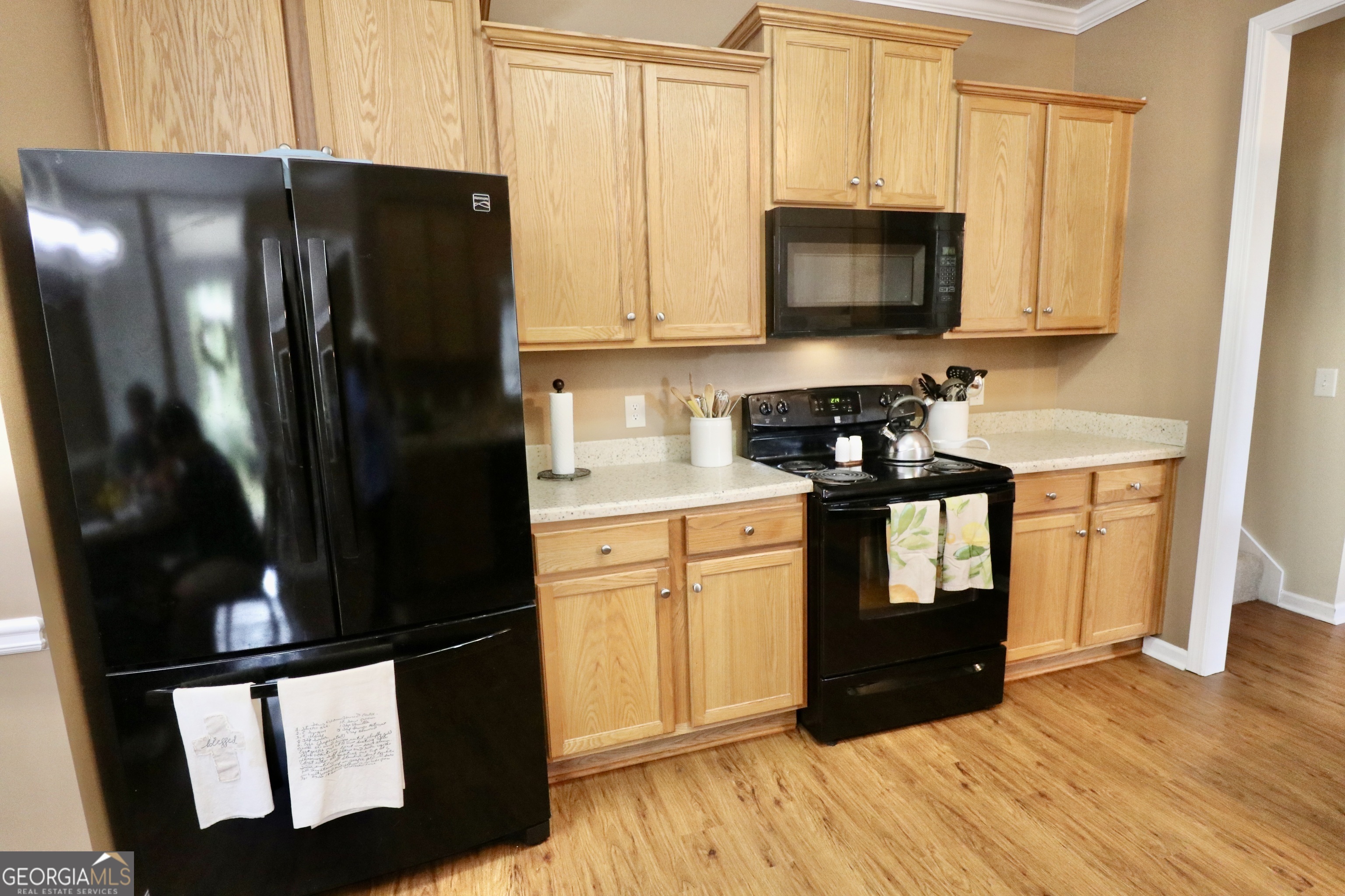 190 Roundtree Way Williamson, GA 30292 - Photo 23 of 73 a kitchen with stainless steel appliances granite countertop a refrigerator a microwave oven with white cabinets and wooden floor