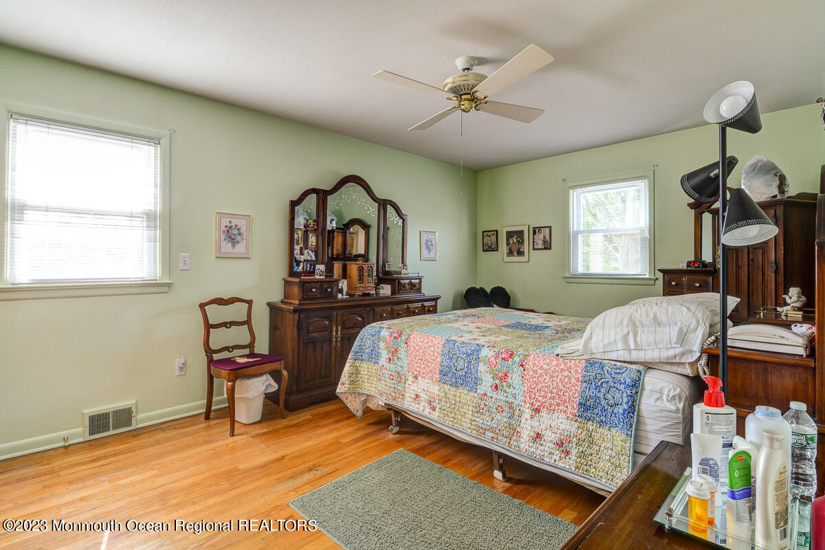 38 Ryan Boulevard Freehold, NJ 07728 - Photo 15 of 22 a bedroom with a bed a chandelier and dresser