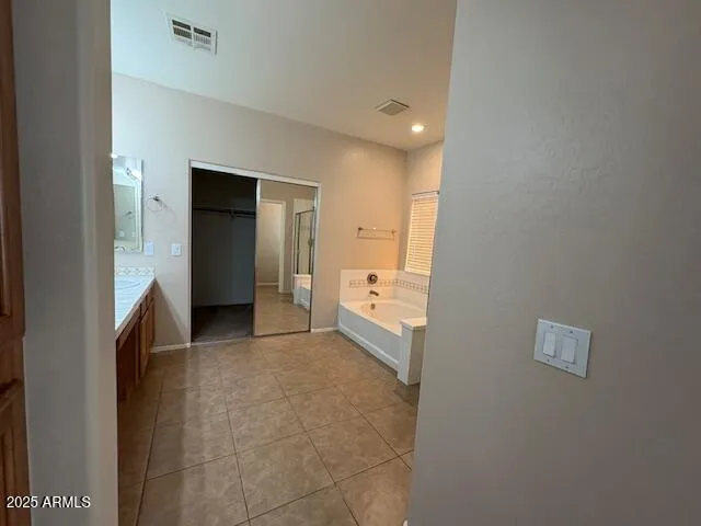 a view of a hallway with bathroom and a sink