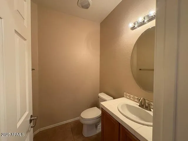 a bathroom with a granite countertop toilet and sink