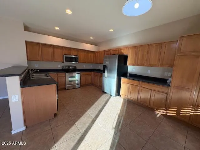 a kitchen with stainless steel appliances granite countertop a stove a sink and a refrigerator