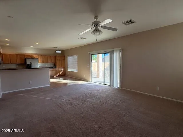 a view of a livingroom with furniture a ceiling fan and window