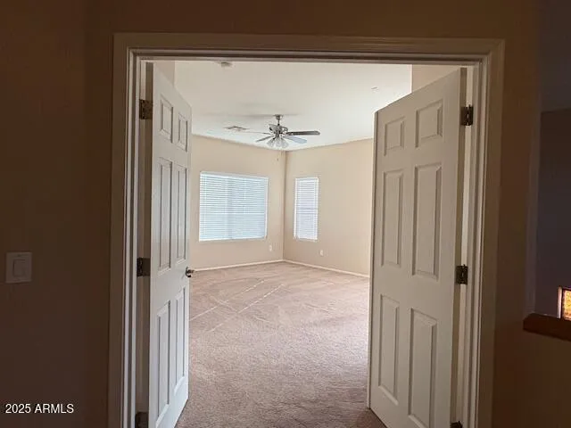 a view of a hallway with a chandelier fan