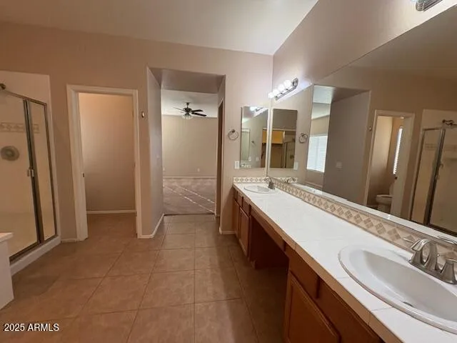 a spacious bathroom with a double vanity sink a mirror and a shower