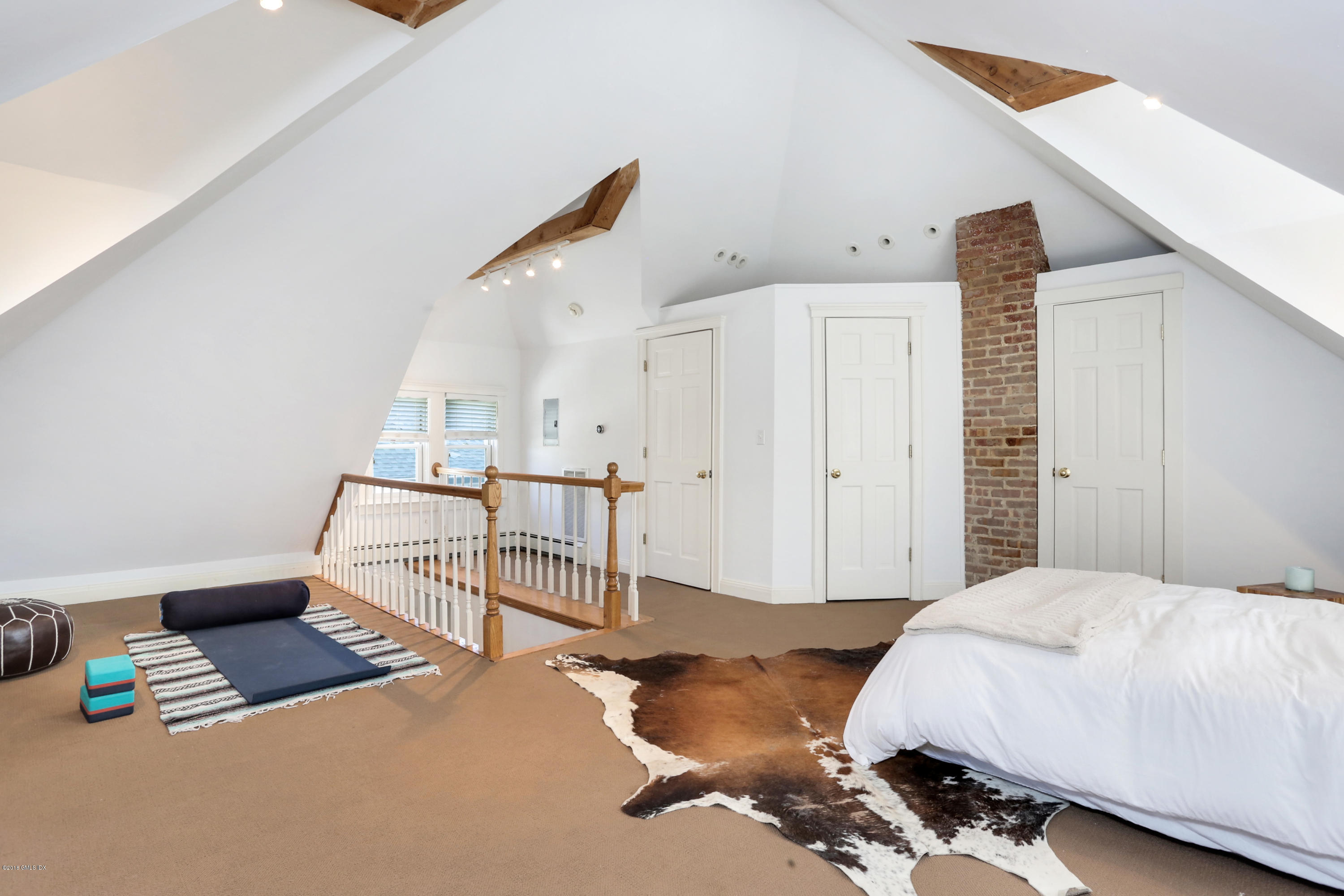 53 Ridge Street Greenwich, CT 06830 - Photo 15 of 17 a bedroom with a bed and white cabinets with wooden floor