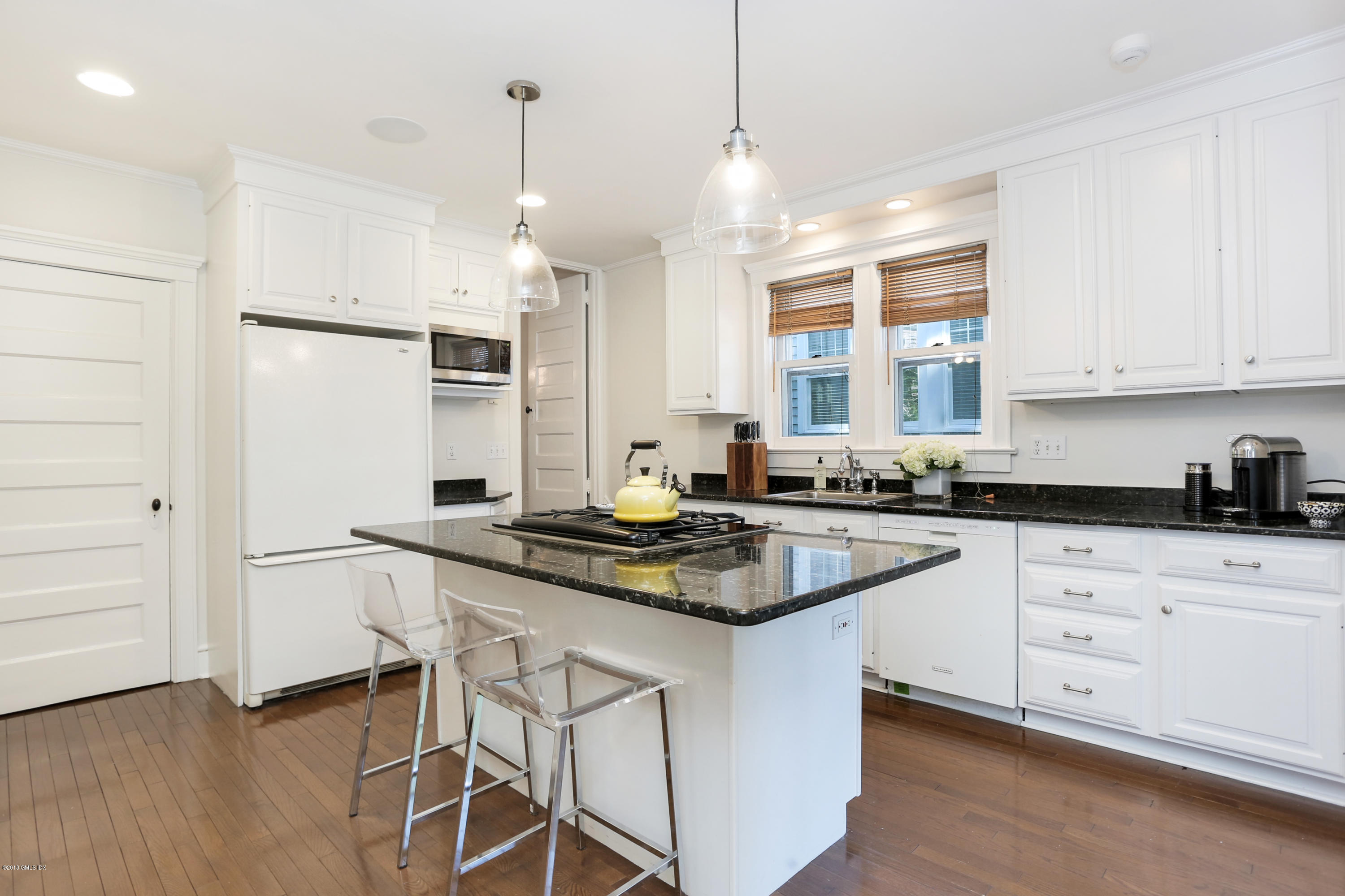 53 Ridge Street Greenwich, CT 06830 - Photo 8 of 17 a kitchen with white cabinets and appliances