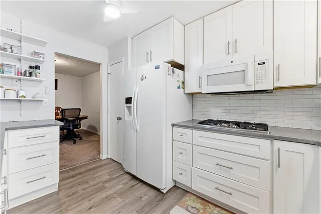 a kitchen with white cabinets and white appliances