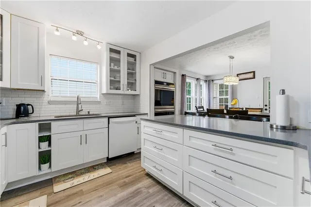 a kitchen with granite countertop white cabinets and white appliances